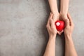 People holding red heart on gray background, top view with space for text. Royalty Free Stock Photo