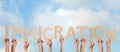 People holding word IMMIGRATION made of cardboard letters against sky. Banner design Royalty Free Stock Photo