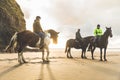 People with horses on the beach on a cloudy day Royalty Free Stock Photo