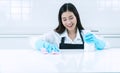 People, housework and housekeeping concept. smile young woman in protective gloves blue wiping dust using spray and Royalty Free Stock Photo