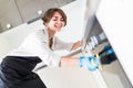 People, housework and housekeeping concept. Close up of woman hand in protective glove with rag cleaning cooker at home kitchen Royalty Free Stock Photo