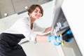 People, housework and housekeeping concept. Close up of woman hand in protective glove with rag cleaning cooker at home kitchen Royalty Free Stock Photo