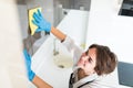 People, housework and housekeeping concept. Close up of woman hand in protective glove with rag cleaning cooker at home kitchen Royalty Free Stock Photo