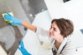 People, housework and housekeeping concept. Close up of woman hand in protective glove with rag cleaning cooker at home kitchen Royalty Free Stock Photo