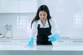 People, housework and housekeeping concept. smile young woman in protective gloves blue wiping dust using spray and Royalty Free Stock Photo
