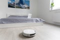 people, housework and technology concept - robot vacuum cleaner at home