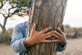 People hugging tree. Nature environment climate change and protection life. Hidden male embrace bonding a trunk at the park. Close Royalty Free Stock Photo