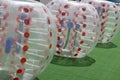 People in an inflatable ball play bumperball