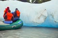 PEOPLE ON INFLATABLE RAFT INSPECTING A GLACIER ICE FLOE