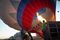 People inflating with burner flame the hot air balloon on the ground