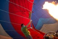 People inflating with burner flame the hot air balloon on the ground