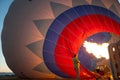 People inflating with burner flame the hot air balloon on the ground