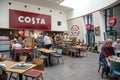 People inside Costa Coffee cafe shopping mall centre service station food court open plan area