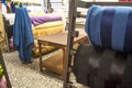 people inside of traditional fabric store with stacks of colorful textiles