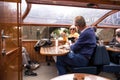 People on interior seating inside a glass roofed sightseeing canal cruise trip boat for tourists