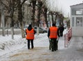 People janitors workers sprinkle slippery streets in the city with sand in winter against ice