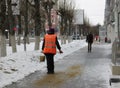 People janitors workers sprinkle slippery streets in the city with sand in winter against ice