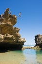 People jumping off a cliff into rock pool