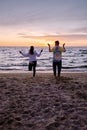 People with jumprope exersise on the beach, couple men and woman exersise together outsied on the beach in the