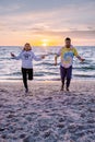 People with jumprope exersise on the beach, couple men and woman exersise together outsied on the beach in the