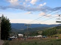 People and kids watch concert on field with ski lift at Wanderlust festival in Colorado Royalty Free Stock Photo