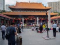People are kneeling and praying in front of the Wong Tai Sin temple in Hong Kong