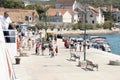 People leaving the pier, and a man working on a Jadrolinija ferry watching from the deck, on island Zlarin, Croatia