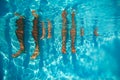 People legs dangling in pool, view from underwater on sunny day Royalty Free Stock Photo