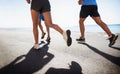People, legs and running at beach for cardio, fitness or outdoor workout together on asphalt or road. Closeup of Royalty Free Stock Photo