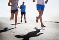 People, legs and running at beach for exercise, fitness or outdoor workout together on asphalt or road. Closeup of Royalty Free Stock Photo