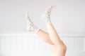 People Legs Up on White Bedroom Studio. Closeup of the Bare Leg of a Beautiful Young Woman Wearing Bright Cute Pastel