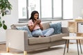 Happy african woman drinking tea or coffee at home Royalty Free Stock Photo