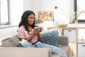 Happy african woman drinking tea or coffee at home Royalty Free Stock Photo