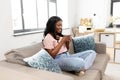 Happy african woman drinking tea or coffee at home Royalty Free Stock Photo