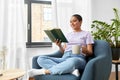 Happy african american woman reading book at home Royalty Free Stock Photo