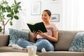 Happy african american woman reading book at home Royalty Free Stock Photo