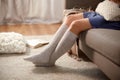woman in socks with pillow sitting on sofa at home Royalty Free Stock Photo