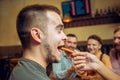 People, leisure, friendship and communication concept - happy friends drinking beer, talking and clinking glasses at bar Royalty Free Stock Photo