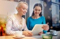 Happy young women drinking tea or coffee at cafe Royalty Free Stock Photo