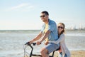 Happy young couple riding bicycle on beach Royalty Free Stock Photo