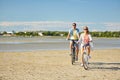 Happy young couple riding bicycles at seaside Royalty Free Stock Photo