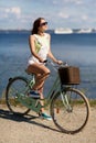Happy young woman riding fixie bicycle at seaside Royalty Free Stock Photo