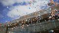 People let go many red, white, blue air balloons fly in cloudness sky. Colors national Russian flag