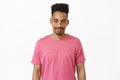 People and lifestyle concept. Attractive smiling african american man in pink t-shirt, looking sassy and confident at