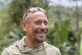 People and lifestyle concept. Happy middle-aged unshaven man with cheerful smile outdoor against green nature background, portrait Royalty Free Stock Photo