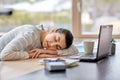 Tired woman sleeping on table with laptop at home Royalty Free Stock Photo