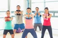 People lifting dumbbell weights with trainer in gym Royalty Free Stock Photo