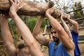 People lifting a heavy wooden log during boot camp Royalty Free Stock Photo