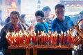 People lighting candles in Wat Mangkorn Kammalawas Leng Nuei Yee , Bangkok, Thiland