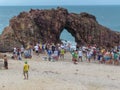 People in line to take a souvenir photo in front of the natural arch of Jericoacoara on Brazil